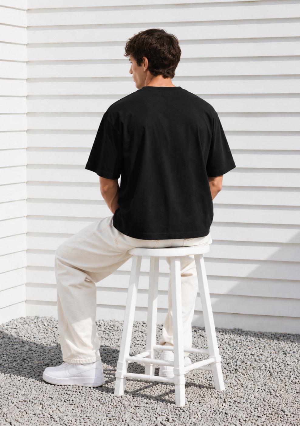 Montx Essential black boxy fit T-shirt for men, made of soft cotton fabric, displayed flat with short sleeves and crew neckline.