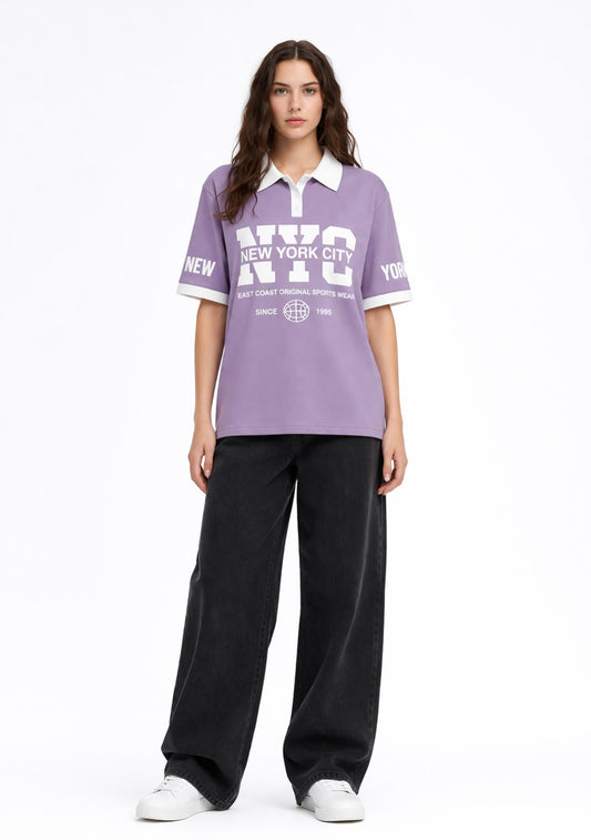 Montx Women’s NYC printed cotton polo T-shirt in lavender, featuring a casual fit and vibrant cityscape design.