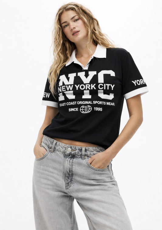 Montx Women’s NYC printed cotton polo t-shirt in black with casual fit, featuring city skyline graphic on the front.